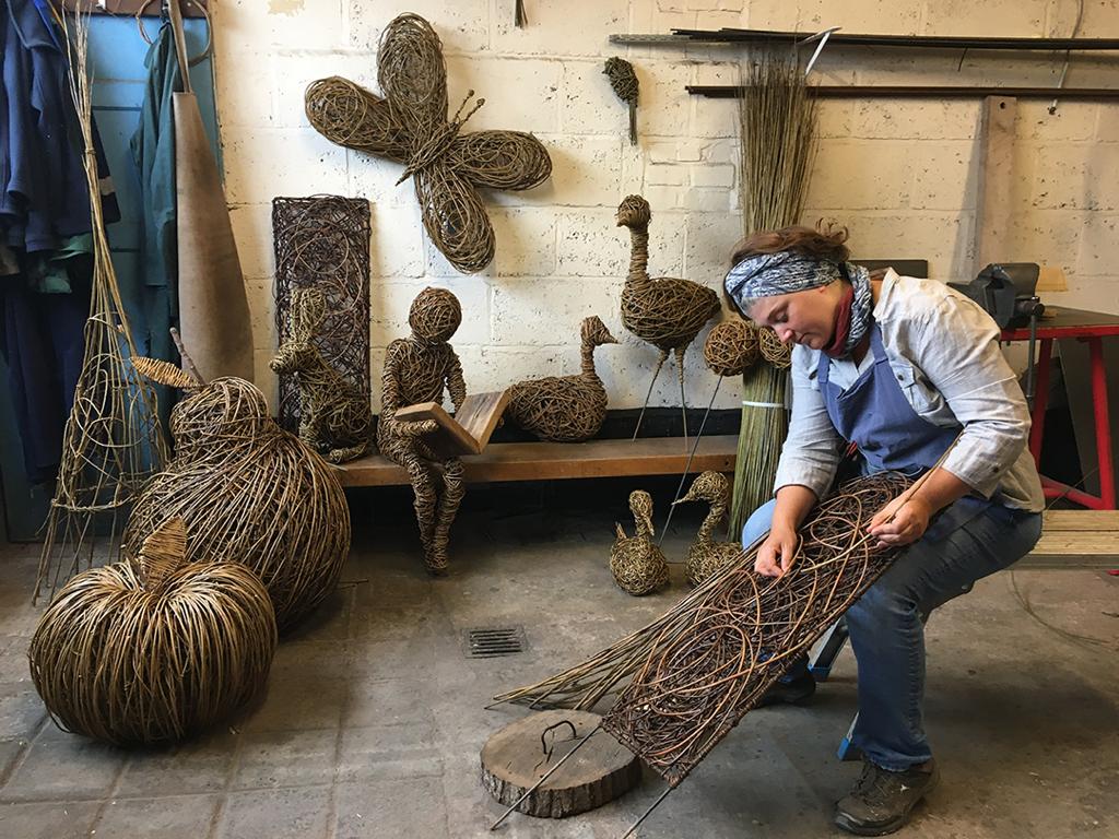 Vik Westaway of Weird Sticks weaving a willow sculpture in her Devon workshop