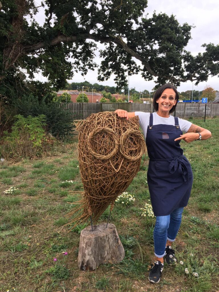 Hannah Westaway of Weird Sticks with a willow owl sculpture sculpture at a Devon workshop