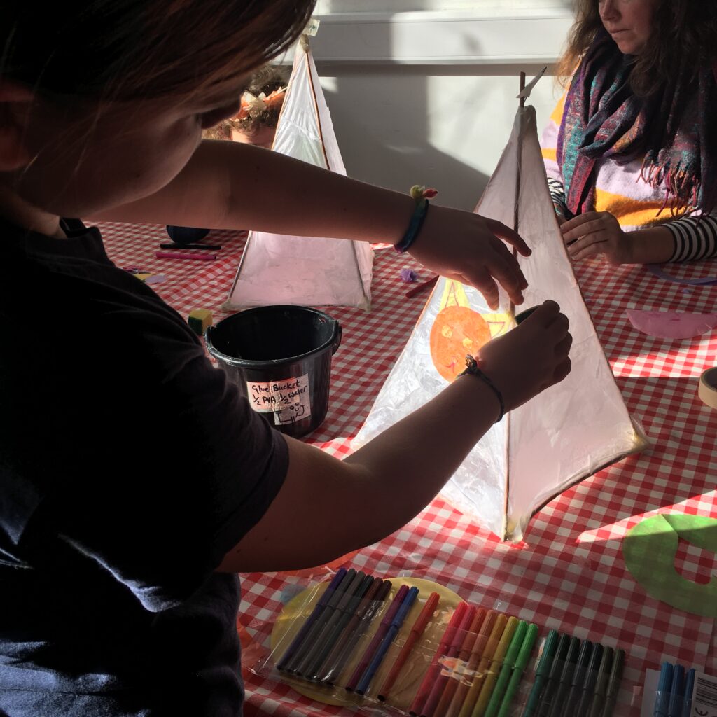 Child decorating their lantern at the Weird Sticks Exeter Carnival Lantern Workshop at Exeter Library