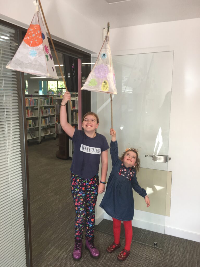 Children holding their completed lanterns at the Weird Sticks Exeter Carnival Lantern Workshop at Exeter Library