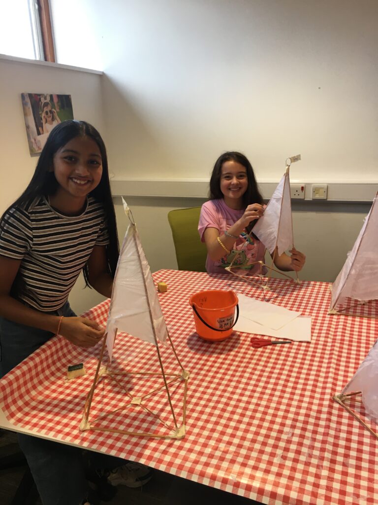 Children constructing their pyramid lanterns at the Weird Sticks Exeter Carnival Lantern Workshop at Exeter Library