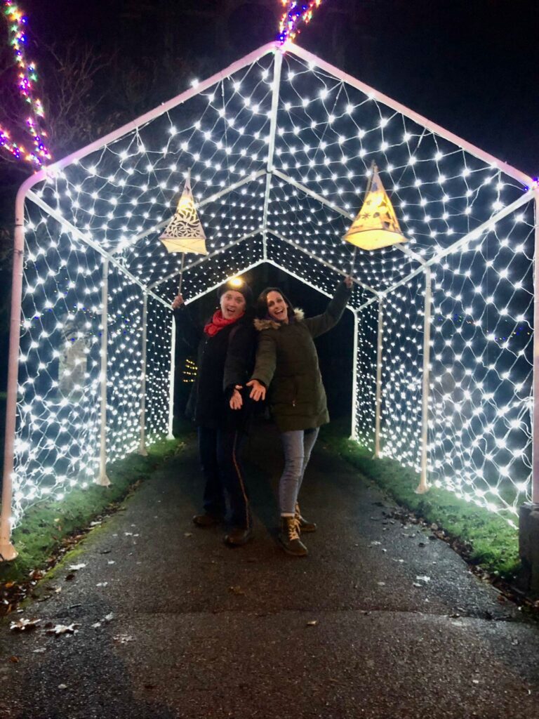 Hannah and Vik from Weird Sticks pose with their glowing lanterns under the light arch at the St Andrews Church Light Garden in Cullompton