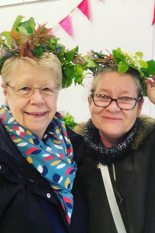 Two smiling participants wearing her willow crown created at the Weird Sticks workshop during the Play Torbay Coronation Breakfast