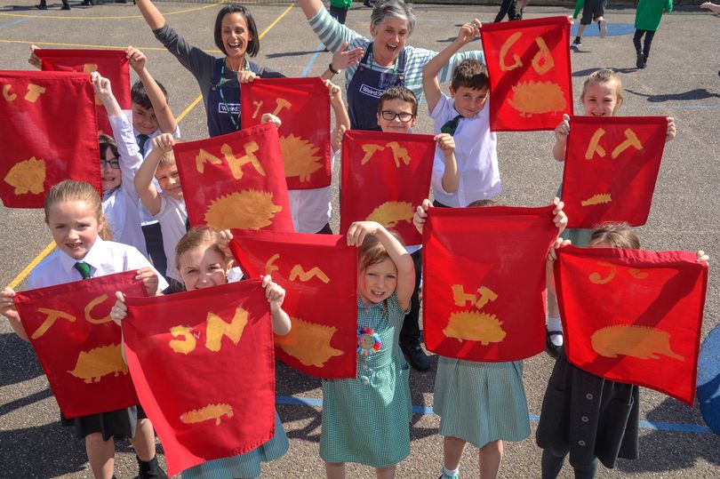 Hannah & Vik from Weird Sticks with pupils at Willowbank Primary School in Cullompton holding up their decorated Roman Flags