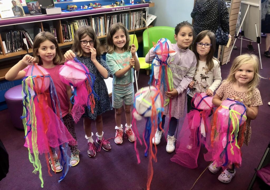 Children displaying their decorated parade jellyfish creations at the Weird Sticks family workshops at Exmouth Library