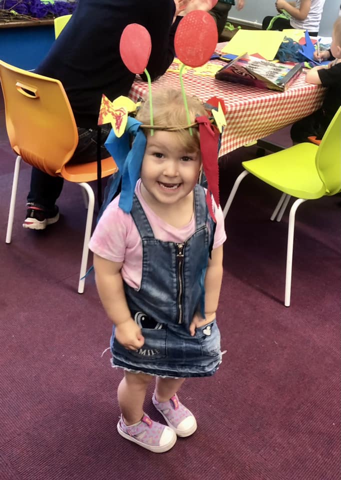 Child wearing their decorated sea creature hat at the Weird Sticks family workshops at Exmouth Library
