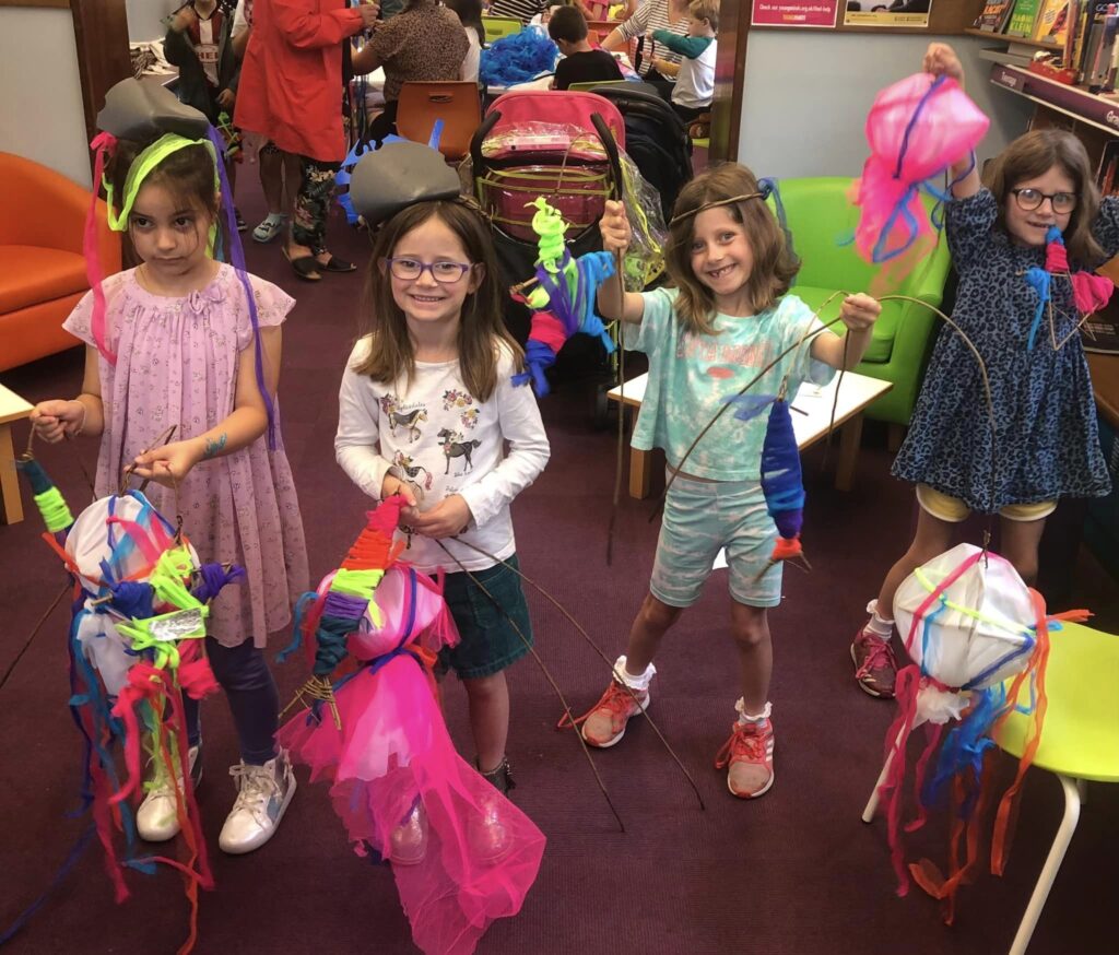 Children displaying their decorated sea creature parade creations at the Weird Sticks family workshops at Exmouth Library