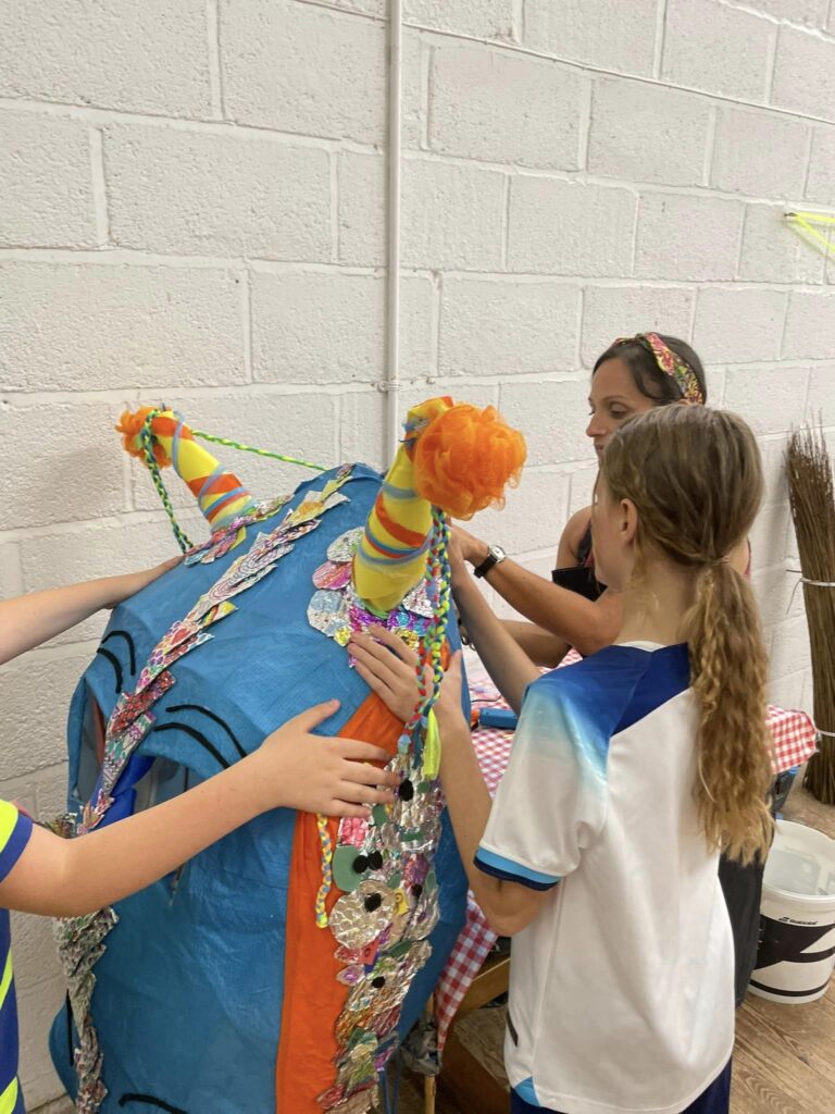 Hannah from Weird Sticks working with young people at Play Torbay to decorate giant sea serpent parade puppet head