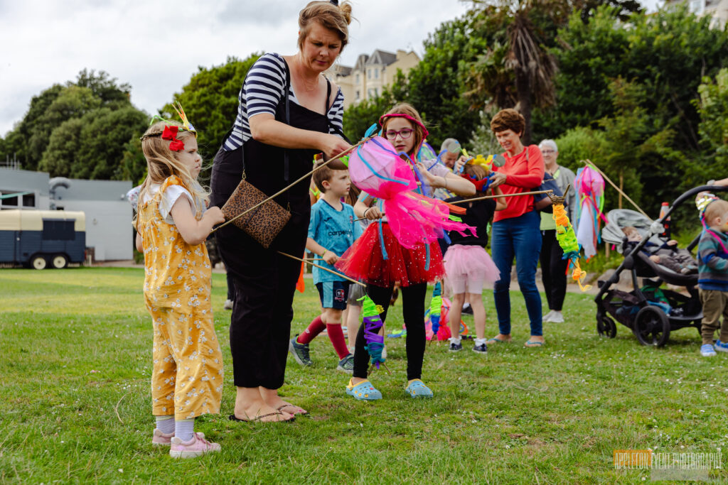 Families participating in the Exmouth Festival samba parade with Weird Sticks assembling their sea creature parade creations and costumes