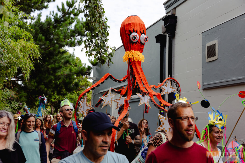 Giant octopus parade puppet made by Weird Sticks being carried as part of the Exmouth Festival samba parade
