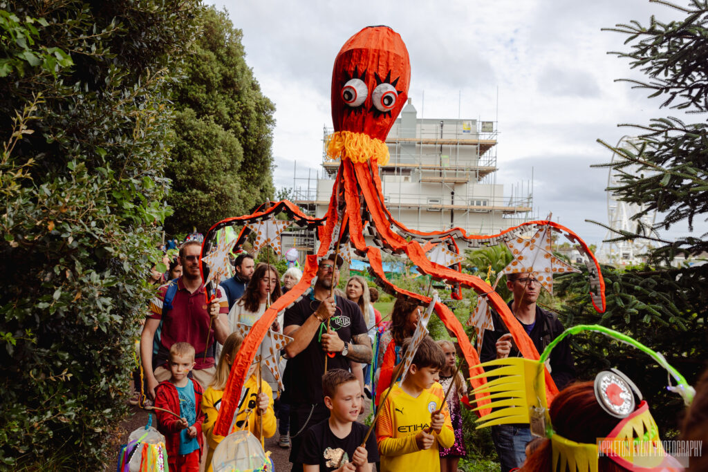 Giant octopus parade puppet made by Weird Sticks being carried as part of the Exmouth Festival samba parade