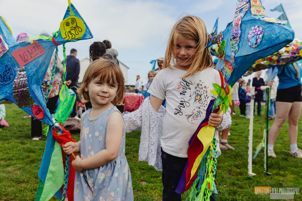 Children displaying small fish parade puppets created with Weird Sticks for Goodrington Seafest