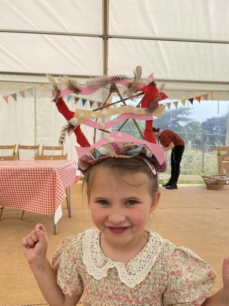 Child wearing their headdress creation at the Weird Sticks workshop at A La Ronde for Exmouth Festival 2024