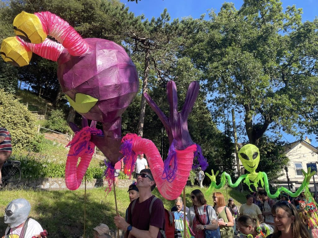 Giant alien parade puppets created by Weird Sticks CIC for the Exmouth Festival samba parade 2024