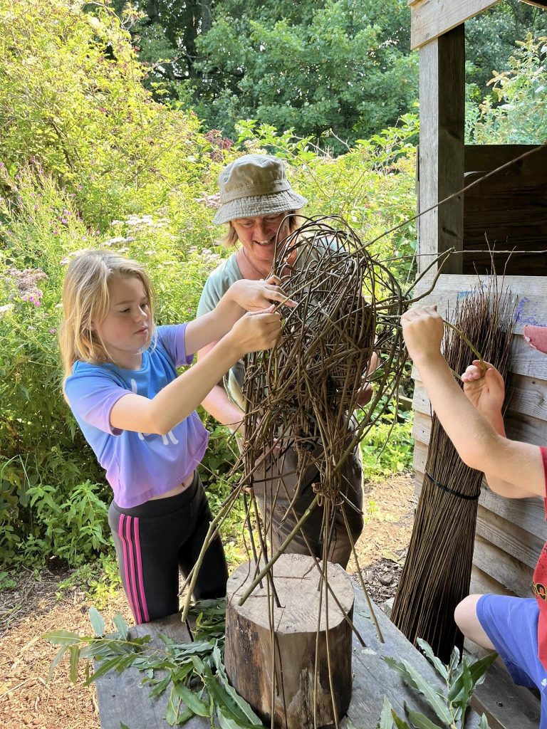 Participants working to create a community owl sculpture with Weird Sticks CIC at Orchard Forest School 