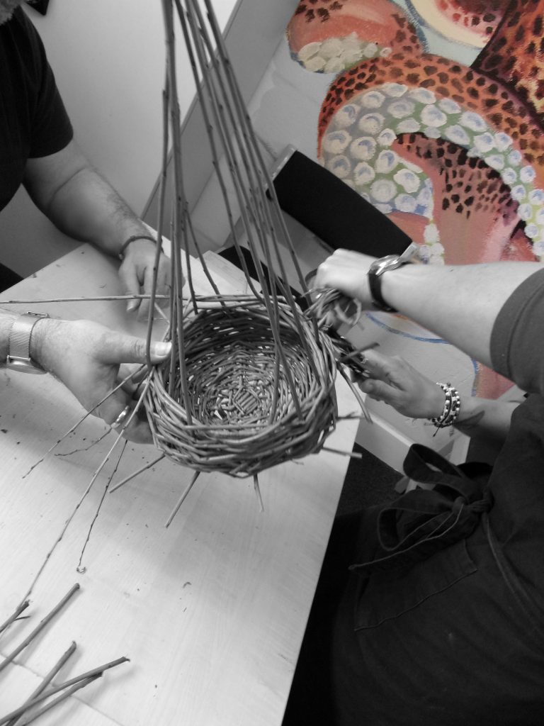 Willow baskets being woven by a participant at HMP Channings Wood during a Weird Sticks workshop as part of the Open Door Project