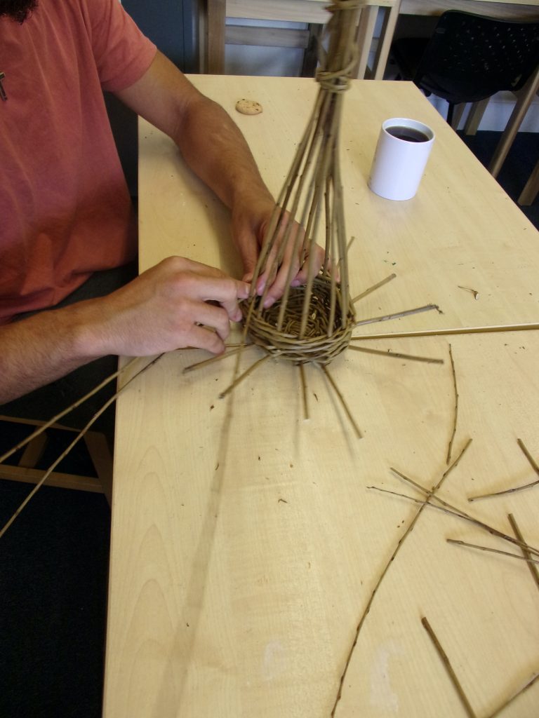 Willow baskets being woven by a participant at HMP Channings Wood during a Weird Sticks workshop as part of the Open Door Project