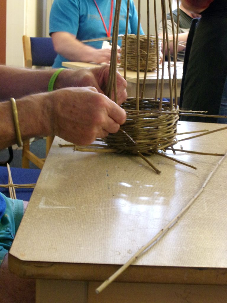 Willow baskets being woven by a participant at HMP Channings Wood during a Weird Sticks workshop as part of the Open Door Project