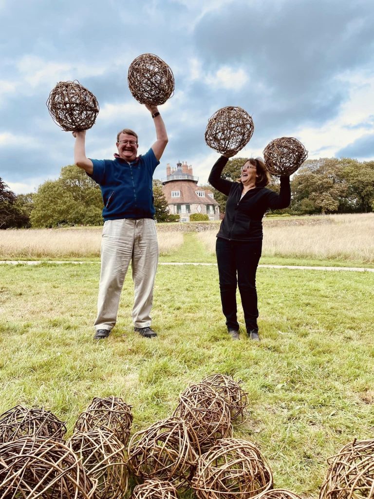 Participants displaying their willow spheres for community ammonite sculpture created with Weird Sticks at A La Ronde